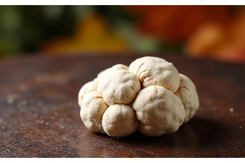 Delicate, irregular white Alba truffle on a rustic wooden board